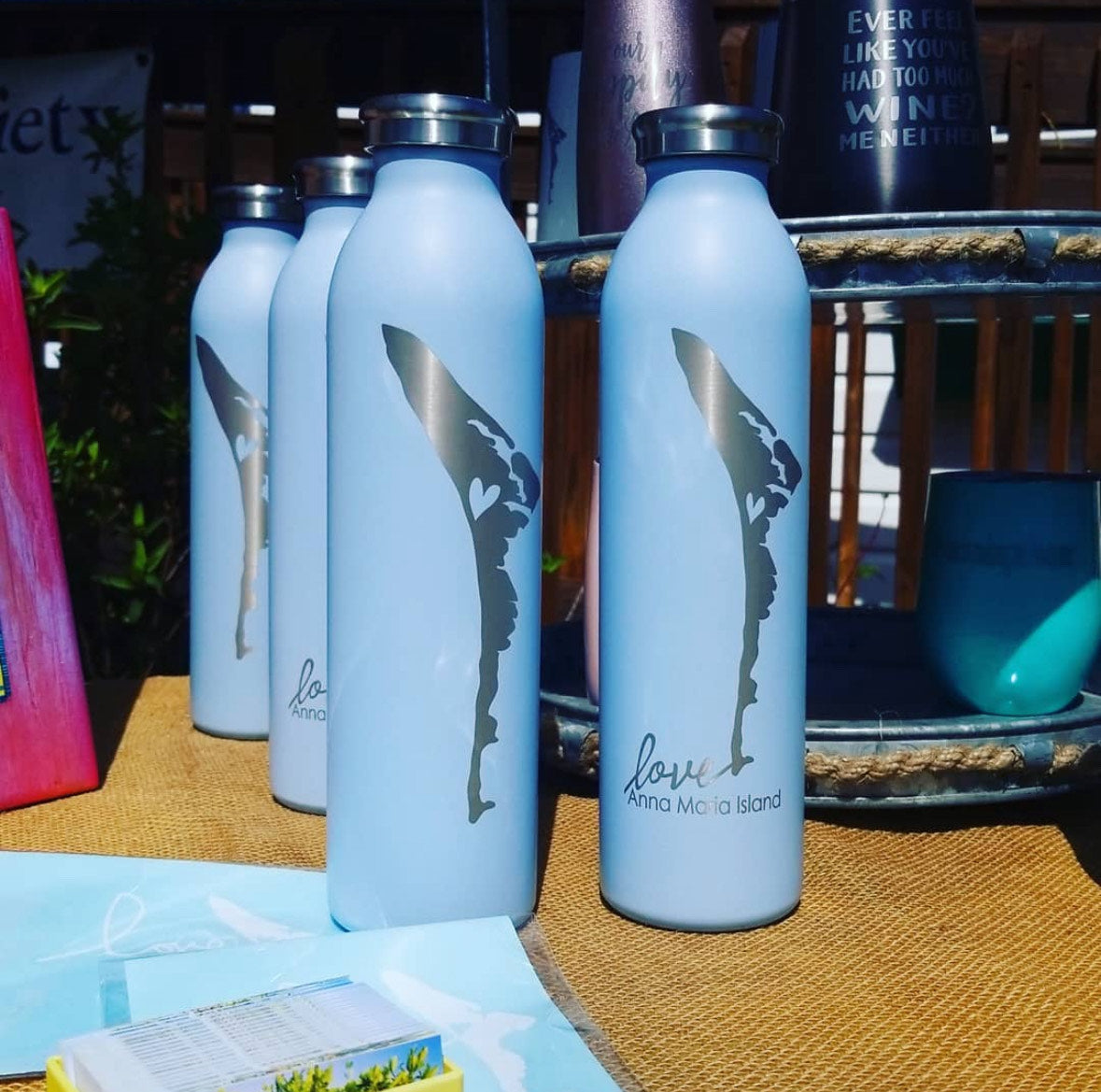 Light Blue Water bottles that are laser engraved with "Anna Maria Island" by Gnarly Mangrove Designs.